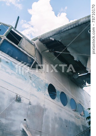 Close-up of a crashed airplane wing. The metal frame and internal parts are visible. Pieces of upholstery and fabric upholstery blow in the wind. Rust and debris 78710170