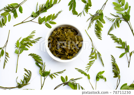 Senna siamea boiled leaves in wooden bowl on white background. 78711230