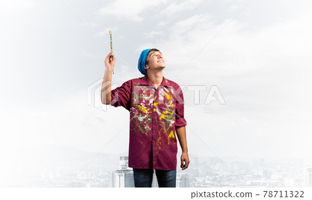 Smiling young painter artist holding paintbrush Smiling young painter artist holding paintbrush 78711322