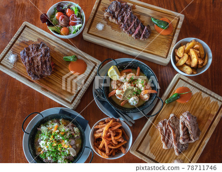 Variety of grilled steak meat dishes, squid dish, fresh vegetables and various ingredients. View from above.Top view. Flat Variety of grilled steak meat dishes, squid dish, fresh vegetables and various ingredients. View from above.Top view. Flat 78711746