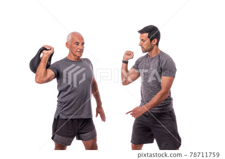 A sports instructor and an elderly man, a client, perform kettlebell exercise movements. On white background. For advertising a fitness center. 78711759