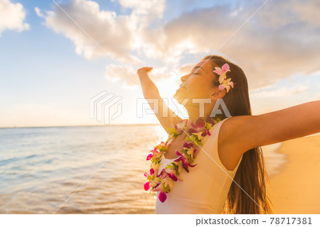 Hawaii hula luau woman wearing hawaiian lei flower necklace on Waikiki beach dancing with open arms free on hawaiian vacation. Asian girl with fresh flowers hair, traditional polynesian dance. Hawaii hula luau woman wearing hawaiian lei flower necklace on Waikiki beach dancing with open arms free on hawaiian vacation. Asian girl with fresh flowers hair, traditional polynesian dance. 78717381