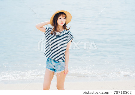 A woman walking on the beach 78718502