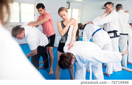 Adults training in pairs at taekwondo class Adults training in pairs at taekwondo class 78719946