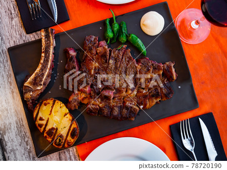 Sliced baked beef chop with potato, jalapenos and aioli 78720190