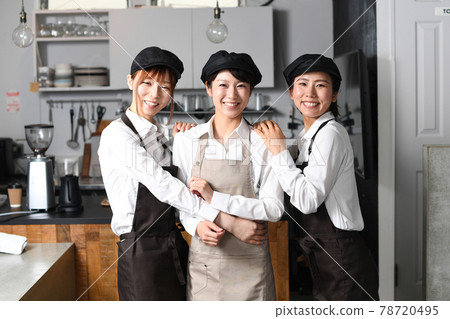 Multiple women in aprons working at a restaurant 78720495