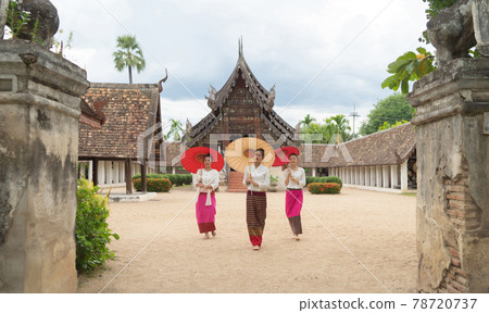 Portrait of group of Asian Shan women girls, Tai Yai, northern Thai people holding an umbrella with traditional Lanna clothes at Wat Ton Kwen temple, decoration. Culture lifestyle. Portrait of group of Asian Shan women girls, Tai Yai, northern Thai people holding an umbrella with traditional Lanna clothes at Wat Ton Kwen temple, decoration. Culture lifestyle. 78720737