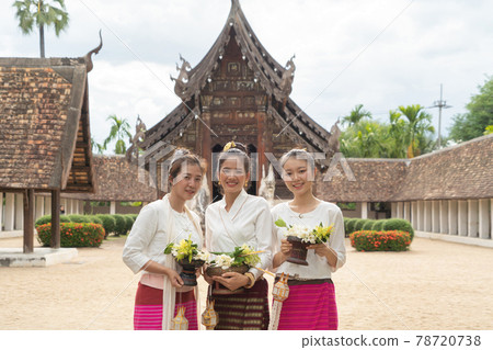 Portrait of group of Asian Shan women girls, Tai Yai, northern Thai people with traditional Lanna clothes holding flowers at Wat Ton Kwen temple, lanterns decoration. Culture lifestyle. 78720738