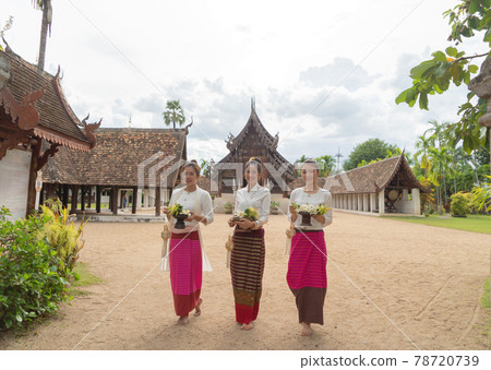 Portrait of group of Asian Shan women girls, Tai Yai, northern Thai people with traditional Lanna clothes holding flowers at Wat Ton Kwen temple, lanterns decoration. Culture lifestyle. Portrait of group of Asian Shan women girls, Tai Yai, northern Thai people with traditional Lanna clothes holding flowers at Wat Ton Kwen temple, lanterns decoration. Culture lifestyle. 78720739