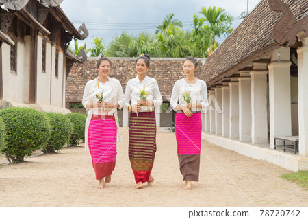 Portrait of group of Asian Shan women girls, Tai Yai, northern Thai people with traditional Lanna clothes holding flowers at Wat Ton Kwen temple, lanterns decoration. Culture lifestyle. 78720742