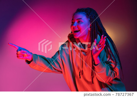 Young woman's portrait on gradient colors studio background in neon. Concept of human emotions. Young woman's portrait on gradient colors studio background in neon. Concept of human emotions. 78727367