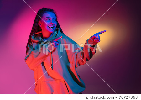 Young woman's portrait on gradient colors studio background in neon. Concept of human emotions. Young woman's portrait on gradient colors studio background in neon. Concept of human emotions. 78727368