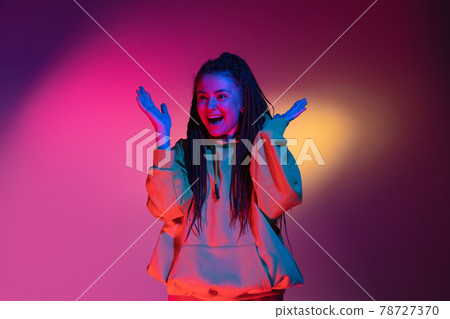 Young woman's portrait on gradient colors studio background in neon. Concept of human emotions. Young woman's portrait on gradient colors studio background in neon. Concept of human emotions. 78727370