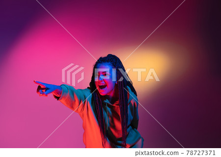 Young woman's portrait on gradient colors studio background in neon. Concept of human emotions. Young woman's portrait on gradient colors studio background in neon. Concept of human emotions. 78727371