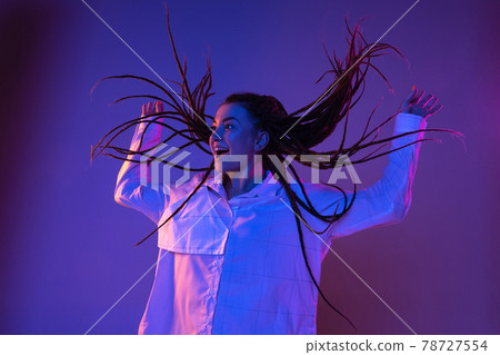 Young woman's portrait on gradient colors studio background in neon. Concept of human emotions. Young woman's portrait on gradient colors studio background in neon. Concept of human emotions. 78727554
