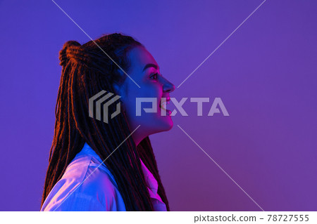 Young woman's portrait on gradient colors studio background in neon. Concept of human emotions. Young woman's portrait on gradient colors studio background in neon. Concept of human emotions. 78727555