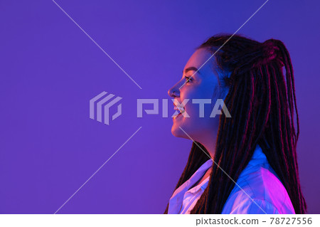 Young woman's portrait on gradient colors studio background in neon. Concept of human emotions. Young woman's portrait on gradient colors studio background in neon. Concept of human emotions. 78727556