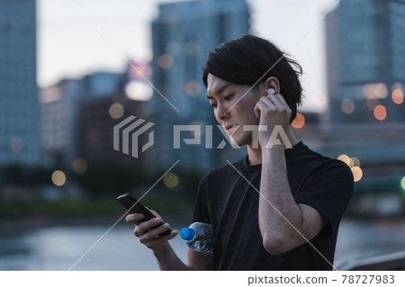 一個準備在戶外聽音樂時跑步的年輕人 一個準備在戶外聽音樂時跑步的年輕人 78727983