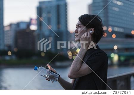 一個準備在戶外聽音樂時跑步的年輕人 一個準備在戶外聽音樂時跑步的年輕人 78727984