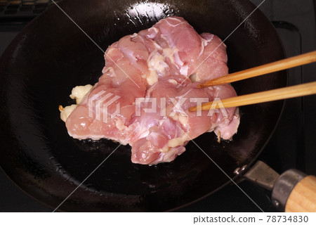 Raw Japanese chicken thighs being cooked on a frying pan 78734830