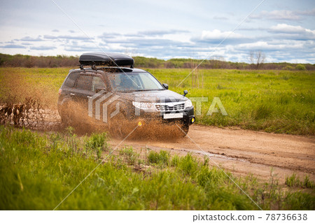 Black Subaru Forester moving at dirty forest road making a lot of water splashes Black Subaru Forester moving at dirty forest road making a lot of water splashes 78736638