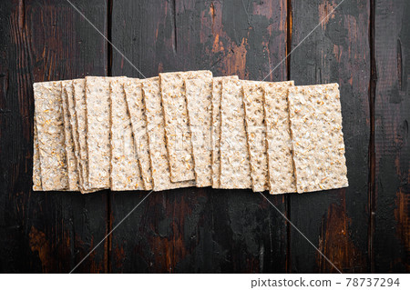 Whole grain crisp bread, on old dark wooden table background, top view flat lay, with copy space for text Whole grain crisp bread, on old dark wooden table background, top view flat lay, with copy space for text 78737294