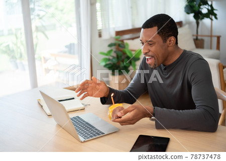 Happy Smiling Black African American man making video call on Laptop with birthday cake Happy Smiling Black African American man making video call on Laptop with birthday cake 78737478