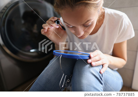 Young woman painting eyelashes with mascara in front of mirror in bathroom 78737885