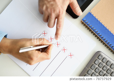 Man and woman filling out questionnaire on desktop closeup 78737929