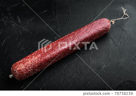 Beef Salami Sausage, on black dark stone background, with copy space for text 78738239