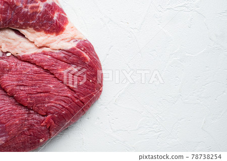 Raw brisket beef cut. Black Angus beef, on white stone background, top view flat lay, with copy space for text Raw brisket beef cut. Black Angus beef, on white stone background, top view flat lay, with copy space for text 78738254