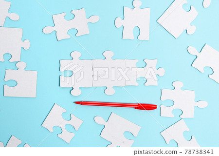 Close-Up White Jigsaw Pattern Puzzle Pieces To Be Connected With Missing Last Piece Positioned On A Flat Lay Background With Different Texture And Paper Supplies Accesories Close-Up White Jigsaw Pattern Puzzle Pieces To Be Connected With Missing Last Piece Positioned On A Flat Lay Background With Different Texture And Paper Supplies Accesories 78738341