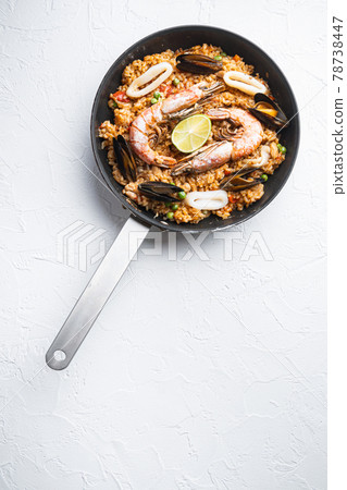 Paella cooked in frying pan on white textured background, flat lay with copy space 78738447