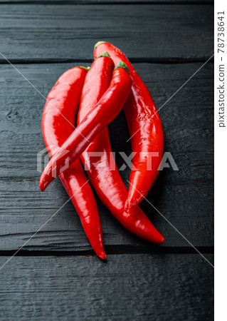 Raw red chili pepper, on black wooden table Raw red chili pepper, on black wooden table 78738641