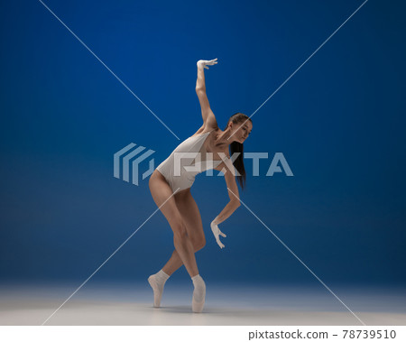 Young beautiful ballerina in action isolated over blue background. Concept of beauty, art, show, theater. Young beautiful ballerina in action isolated over blue background. Concept of beauty, art, show, theater. 78739510