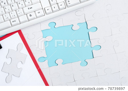 Close-Up White Jigsaw Pattern Puzzle Pieces To Be Connected With Missing Last Piece Positioned On A Flat Lay Background With Different Texture And Paper Supplies Accesories Close-Up White Jigsaw Pattern Puzzle Pieces To Be Connected With Missing Last Piece Positioned On A Flat Lay Background With Different Texture And Paper Supplies Accesories 78739897