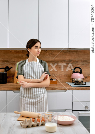 beautiful woman stands near table on kitchen 78740364