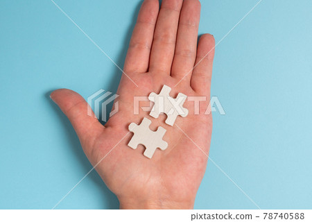 Close-Up White Jigsaw Pattern Puzzle Pieces To Be Connected With Missing Last Piece Positioned On A Flat Lay Background With Different Texture And Paper Supplies Accesories Close-Up White Jigsaw Pattern Puzzle Pieces To Be Connected With Missing Last Piece Positioned On A Flat Lay Background With Different Texture And Paper Supplies Accesories 78740588