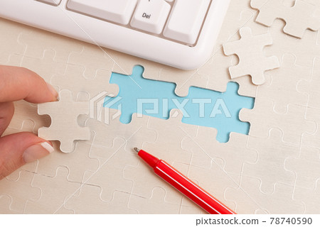 Close-Up White Jigsaw Pattern Puzzle Pieces To Be Connected With Missing Last Piece Positioned On A Flat Lay Background With Different Texture And Paper Supplies Accesories 78740590