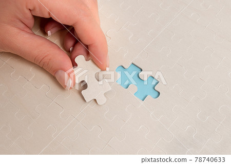 Close-Up White Jigsaw Pattern Puzzle Pieces To Be Connected With Missing Last Piece Positioned On A Flat Lay Background With Different Texture And Paper Supplies Accesories 78740633