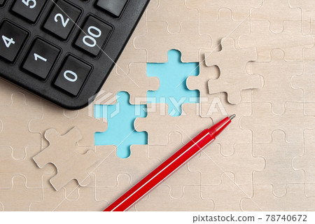 Close-Up White Jigsaw Pattern Puzzle Pieces To Be Connected With Missing Last Piece Positioned On A Flat Lay Background With Different Texture And Paper Supplies Accesories Close-Up White Jigsaw Pattern Puzzle Pieces To Be Connected With Missing Last Piece Positioned On A Flat Lay Background With Different Texture And Paper Supplies Accesories 78740672
