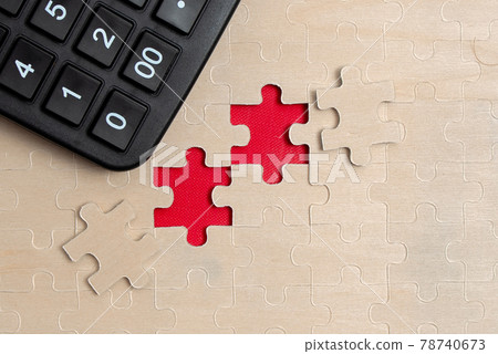 Close-Up White Jigsaw Pattern Puzzle Pieces To Be Connected With Missing Last Piece Positioned On A Flat Lay Background With Different Texture And Paper Supplies Accesories Close-Up White Jigsaw Pattern Puzzle Pieces To Be Connected With Missing Last Piece Positioned On A Flat Lay Background With Different Texture And Paper Supplies Accesories 78740673