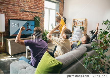 Group of friends watching TV, sport match together. Concept of friendship, leisure activity, emotions Group of friends watching TV, sport match together. Concept of friendship, leisure activity, emotions 78741545