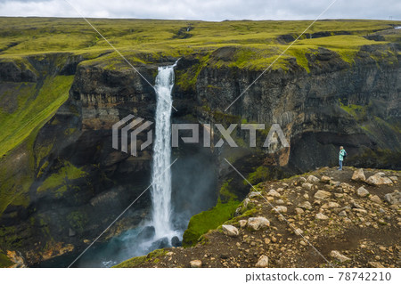 Aerial view of woman with backpack enjoying Haifoss waterfall of Iceland Highlands Aerial view of woman with backpack enjoying Haifoss waterfall of Iceland Highlands 78742210