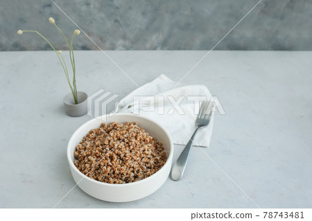 Bowl of buckwheat on a grey concrete background in minimalistic style. Concept of healthy food.  78743481