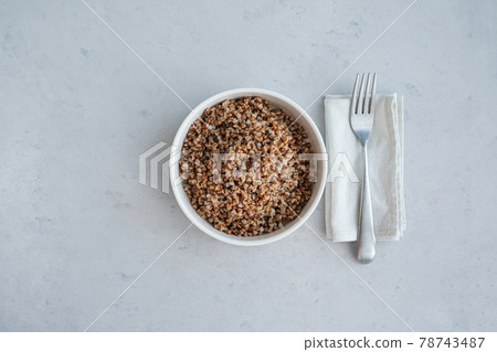 Bowl of buckwheat on a grey concrete background in minimalistic style. Concept of healthy food.  78743487