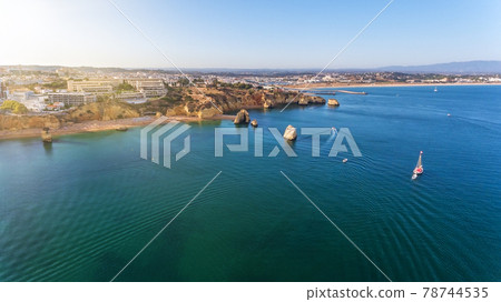 Dona Ana Beach in Lagos, Algarve - Portugal. Portuguese southern golden cliffs. Camilo and pinhao beach. Aerial view with city. Sunny day. 78744535