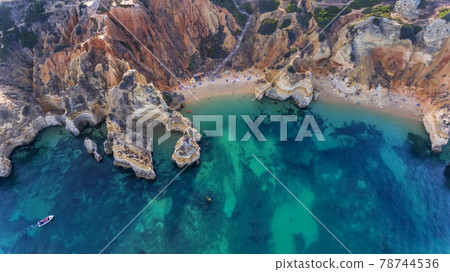 Camilo Beach in Lagos, Algarve - Portugal. Portuguese southern golden coast cliffs. Tourists on the beach. Sunny day aerial view. Camilo Beach in Lagos, Algarve - Portugal. Portuguese southern golden coast cliffs. Tourists on the beach. Sunny day aerial view. 78744536
