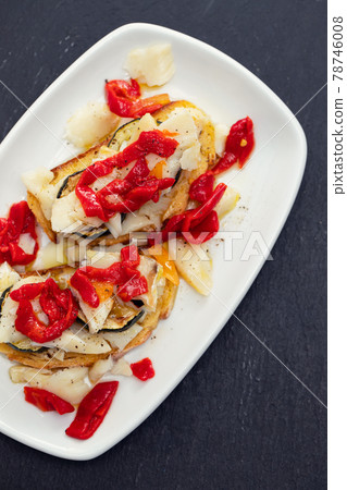 corn bread with cod fish and courgette on white dish 78746008