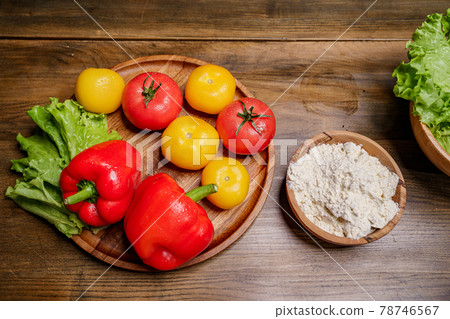 a wooden bowl of flour and vegetables on the kitchen table. a wooden bowl of flour and vegetables on the kitchen table. 78746567